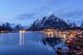 Reine, snow covered mountains in the background and the fishing cabins Rorbu in the foreground, Lofoten Islands, Norway Royalty Free Stock Photo