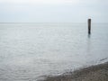 Reinforced concrete pile sticking out of the water. Remains of an old bridge in the sea. Ruined pier. Abandoned. Armature at sea. Royalty Free Stock Photo