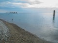 Reinforced concrete pile sticking out of the water. Remains of an old bridge in the sea. Ruined pier. Abandoned. Armature at sea. Royalty Free Stock Photo