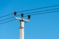 reinforced concrete pillar with high-voltage wires against a clear blue sky. Transmission of electricity by wires over long Royalty Free Stock Photo