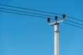 reinforced concrete pillar with high-voltage wires against a clear blue sky. Transmission of electricity by wires over long Royalty Free Stock Photo