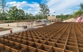 Reinforcing bars grid for ferroconcrete. Building foundations in green trees