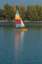 rainbow catamaran sailing on the lake of reiningue on autumnal trees background