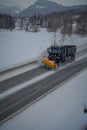 Reinli, Norway - March 26, 2018: Above view of snow-removing machine cleans the road from the snow in the morning