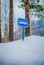 Reinli, Norway - March 26, 2018: Outdoor view of sign of bus stop at one side during winter in the road, almost covered Royalty Free Stock Photo