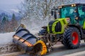Reinli, Norway - March 26, 2018: Outdoor view of snow-removing machine cleans the snow in the morning covered trees and