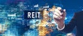 REIT - Real Estate Investment Trust theme with businessman in a bokeh neon light trails city background