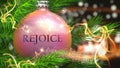 Rejoice and Christmas holidays, pictured as a Christmas ornament ball with word Rejoice and magic beams to symbolize the