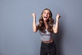 Rejoicing young woman screaming with joy celebrating victory win success isolated on grey background Royalty Free Stock Photo