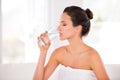 Rejuvenating her skin. Side view of a beautiful woman drinking a glass of water. Royalty Free Stock Photo