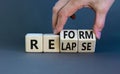 Relapse or reform symbol. Businessman turns cubes and changes the word `relapse` to `reform`. Beautiful grey background. Busin