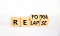 Relapse or reform symbol. Turned wooden cubes and changed the word `relapse` to `reform`. Beautiful white background. Business