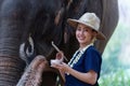 Relationship between Asian people and elephant, Thai lady beautiful dressing traditional northern style touching elephants trunk