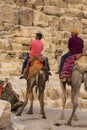 The relationship between Bedouins and tourists in the Sahara desert. Riding on dromedaries. The great pyramids of Giza.