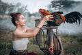 The relationship between a chicken and a person. Asian cute girl wearing Thai traditional dress and her chicken sitting on bicycle Royalty Free Stock Photo