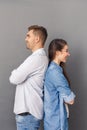 Relationship Concept. Young couple studio standing back to back isolated on grey smiling joyful Royalty Free Stock Photo