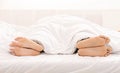 Bare feet of couple sleeping separately in bed Royalty Free Stock Photo