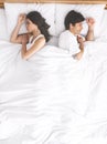 Upset couple sleeping separately on their bed