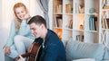 Relationship hobby couple guitar man woman home Royalty Free Stock Photo