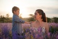 Relationship issue concept cute little boy touch his hurted young mother asking forgiveness and apologize outdoor summer flower