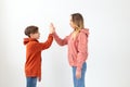 Relationship, mothers day, children and family concept - teen boy giving high five to his mom on white background Royalty Free Stock Photo