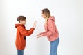 Relationship, mothers day, children and family concept - teen boy giving high five to his mom on white background Royalty Free Stock Photo