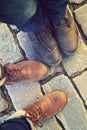 Relationship in a pair of lovers, two side by side. feet in shoes on the paving slabs.