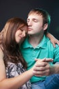 Relationships Concepts. Portrait of Lovely Caucasian Couple Sitting Together and Embracing With Eyes Closed. Against Black