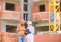 Relationships between construction clients and participants building industry. Woman engineer and builder communicate at Royalty Free Stock Photo