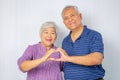 Relationships, love and old people concept -  Happy seniors couple showing hand heart gesture and smiling Royalty Free Stock Photo