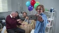 Relatives visit girl who lie on the bed in the hospital, boy take a photo