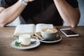 Relax Asian man drink coffee and read book in a modern style coffee shop Royalty Free Stock Photo