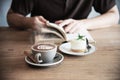 Relax Asian man drink coffee and read book in a modern style coffee shop Royalty Free Stock Photo