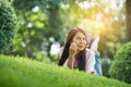 Relax beautiful asian woman smiling face Lying down on green grass field in outdoors garden park enjoy nature morning. Freedom Royalty Free Stock Photo