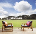 Relax chairs on wood terrace with grass field and beautiful sky Royalty Free Stock Photo