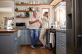 Relax, coffee and elderly couple in a kitchen, bonding and talking in their home together. Love, woman and mature man Royalty Free Stock Photo