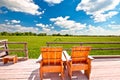 Relax deck chairs in agricultural landscape. Green wheat field under blue sky view Royalty Free Stock Photo