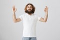 Relax, everything is under control. Portrait of confident handsome mature eastern guy with curly hair and beard raising