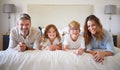 Relax, family and bed portrait with happy parents of young children in cozy Canada holiday home. Love, care and support Royalty Free Stock Photo