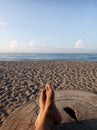 Relax feet against blue sky over the sea. Background of relaxation feet on wood, enjoying the sunlight in the beach. Royalty Free Stock Photo