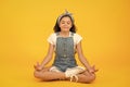 Relax and get comfortable. Small girl sit in yoga posture on yellow background. Little child enjoy yoga training. Yoga