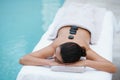 Relax, hot stone massage and woman at pool at spa for health, zen wellness and luxury holistic treatment. Self care Royalty Free Stock Photo
