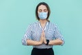 Relax and meditation. Portrait of calm middle aged woman with surgical medical mask standing and doing yoga alone