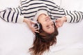 Relax, music and happy woman on bed with headphones from above, happiness and wellness in home. Audio, smile and girl in