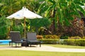 Umbrellas and sunbeds on the pool. A quiet place at a resort in the tropics. Place for sunbathing and lying.