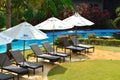 Umbrellas and sunbeds on the pool. A quiet place at a resort in the tropics. Place for sunbathing and lying.