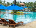 Relax by The Pool in Luxury Hotel on The Island of Thailand. Couple of Wooden Chair under The Umbrella Royalty Free Stock Photo