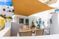 Terrace with chairs and table in Santorini caldera hotel, cozy holiday concept