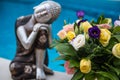 Relax statuette Buddha with flower on pool background