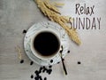 Relax Sunday, Welcoming Sunday weekend with text Sunday greeting and a cup of morning coffee on white wooden table background. Royalty Free Stock Photo